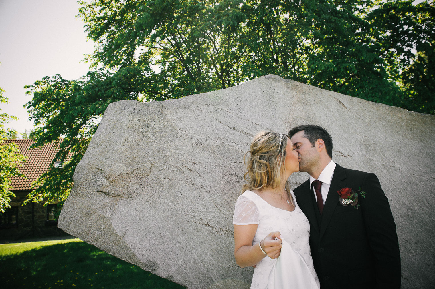 Brudpar som kysser varann vid Clas Hakes stenskulptur i närheten av St Birgittas kapell.